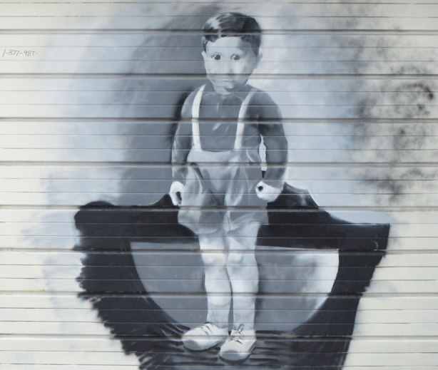 a painting in grey tones of a young boy in old fashioned shorts and long sleeved top, standing. 