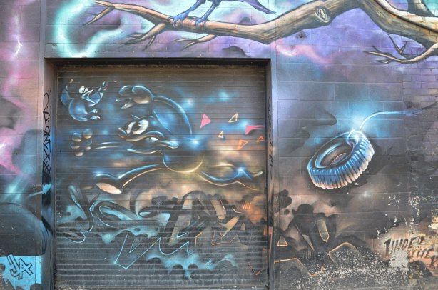 part of a larger mural - a cat chases a bird, under a tree branch, tire rope swing on the tree in the picture too, the cat looks a bit like Felix the cat cartoon character