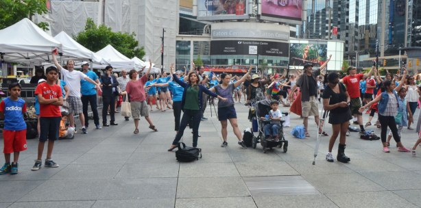 people dancing at Yonge Dundas Square as a group, part of an event called Sharing Dance