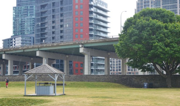 from the grounds of Fort York looking south to the Gardiner and the condos built beyond it. Grass field in the foreground. 