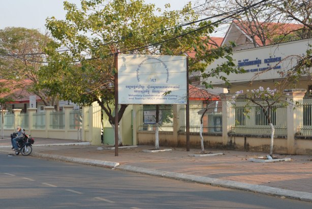 A man rests on his motorcycle beside the road by the HIV clinic in Kampong Cham 