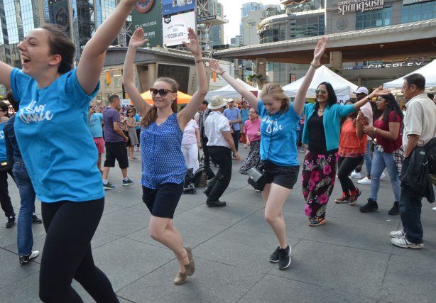 people dancing at Yonge Dundas Square as a group, part of an event called Sharing Dance