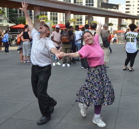 people dancing at Yonge Dundas Square as a group, part of an event called Sharing Dance - a couple dancing together