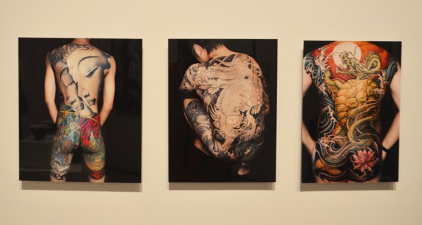 Three pictures of the backsides of men, each with a large picture tattoo from neck to thigh. Chinese art pictures as tattoos