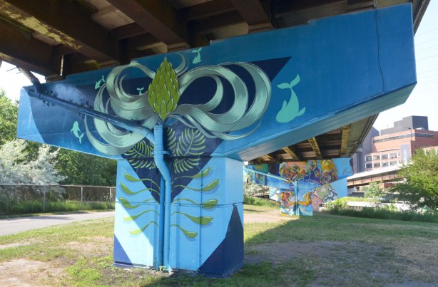 concrete support, or bent, under a ramp has been painted with a mural based on a large dark blue triangle