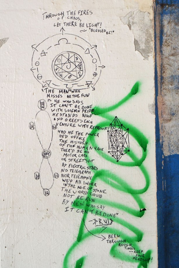many words written on the wall of an underpass, along with some line drawings. by druid, 