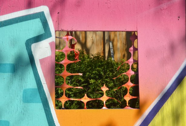 a small square window cut into painted construction hoardings