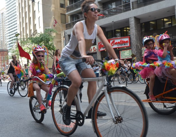 kids riding on bikes with their mothers in a dyke march