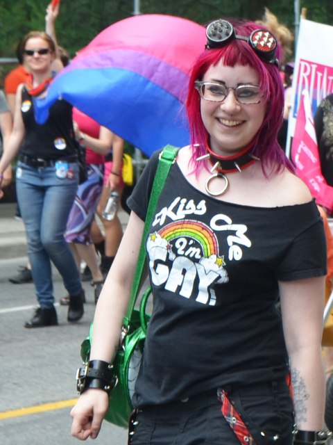 a young woman with magenta coloured hair and a t shirt that says "Kiss me i'm gay"