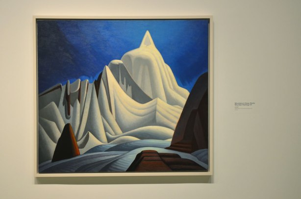 a Lawren Harris painting of a snow covered mountain, blue sky in the background.