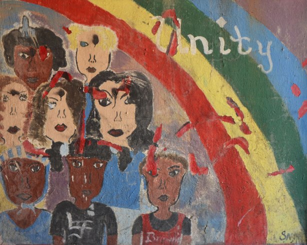 old mural that is not in good shape, a rainbow in the top right corner with the word unity written on it. A number of faces in the rest of the mural, men and women, different colours.