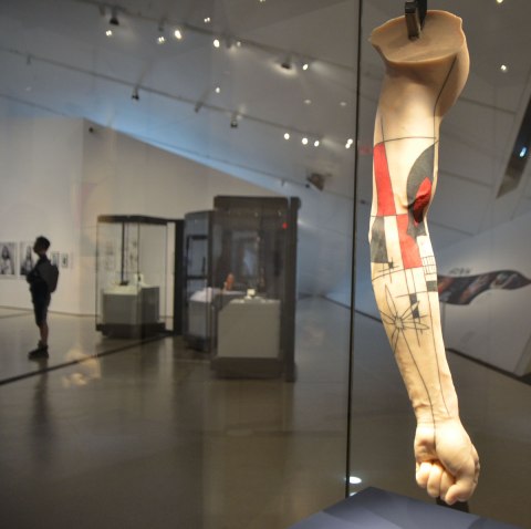 a silicone arm has been tattooed with a design that looks something like a cross between Frank Lloyd Wright and Mondrian. It is in a glass showcase in a museum.