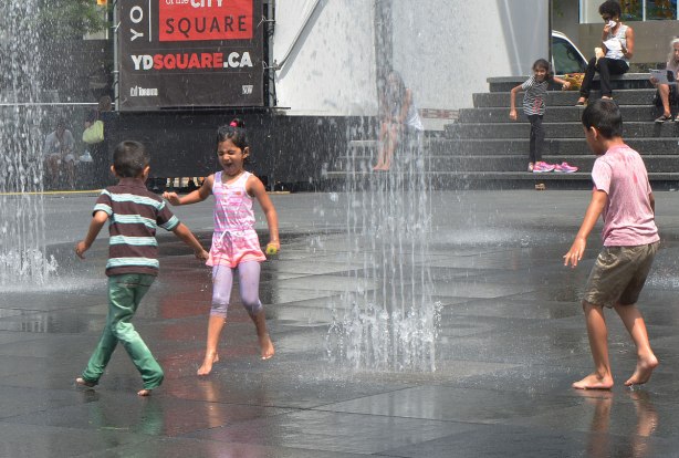 young children play in the fountains at dundas square