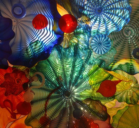 bits of coloured glass, circular shapes, ridges, back lit, 