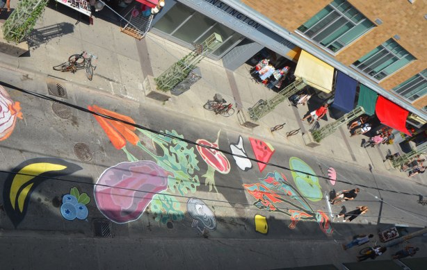 view from above of a mural on a street, fruits and vegetables, carrotes, eggplant, watermelon, beet, mushroom, lemon, 