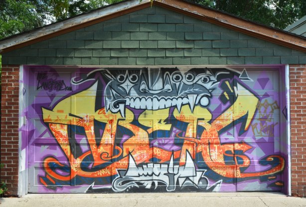 garage door in a laneway covered with streetart painting