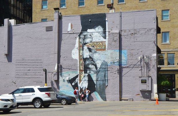 mural on a lavendar coloured wall, a hand pointing down. 