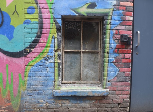 a low window, close to the ground, with a green arrow painted around it.