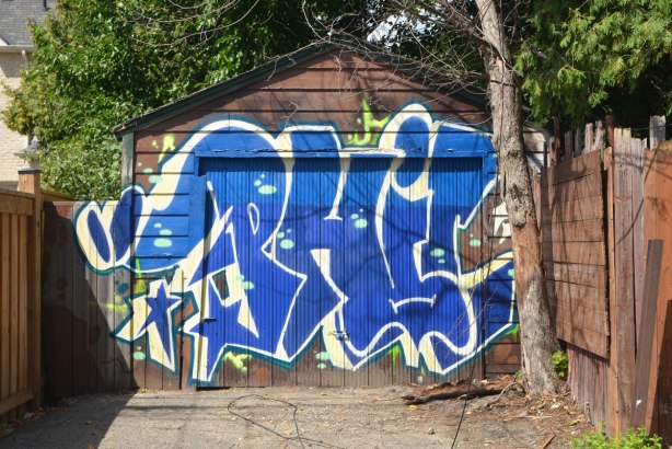 large blue letters P H I L in street art form on a garage door 