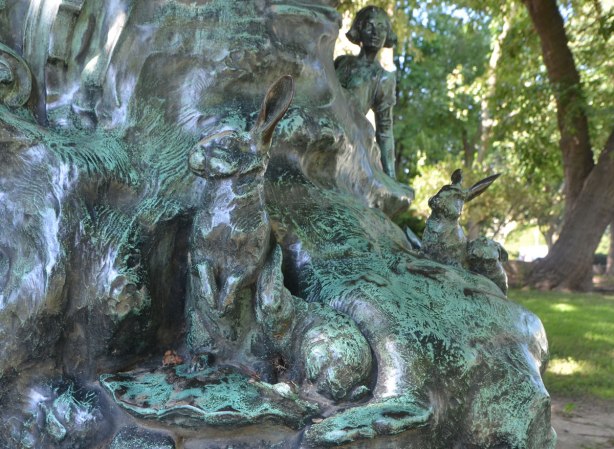 part of a sculpture, some rabbits, a fairy poking her head up 