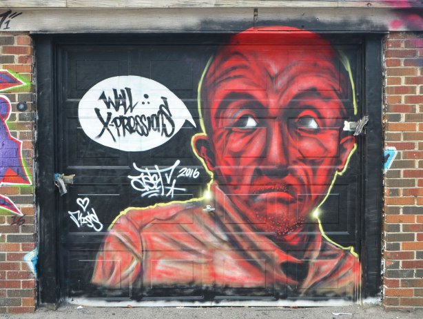 street art mural on a garage door, head and shoulders of a man in red tones, 