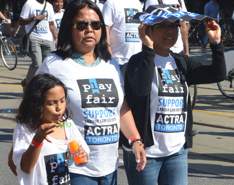 members of the actra union walking in a parade, two women and a girl blowing bubbles