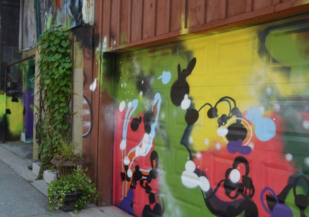 street art on garages, ivy on walls, alley