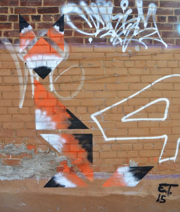 a street art picture of a fox made of triangles in orange black and white 