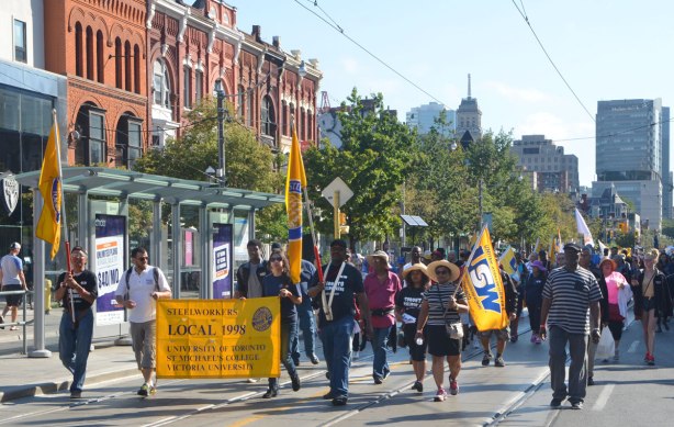 steelworkers march in a labour day parade on Queen St. West with their yellow banner