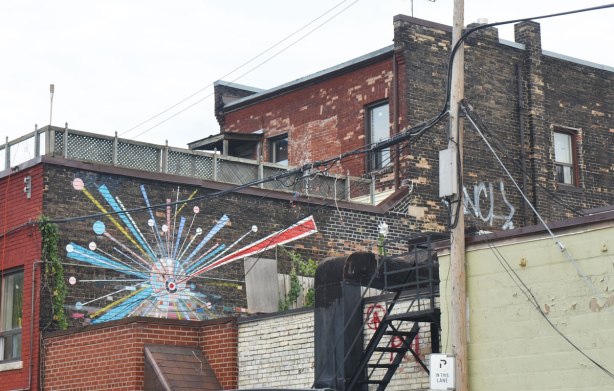 upper level of a store, backing onto a parking lot, painting on the exterior wall of rays eminating from a center circular source 