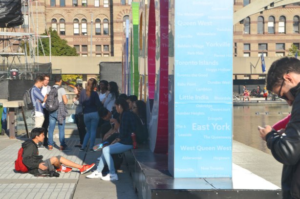 a group of teenagers, school kids, after school, hanging out behind the letters of the 3D Toronto sign. 