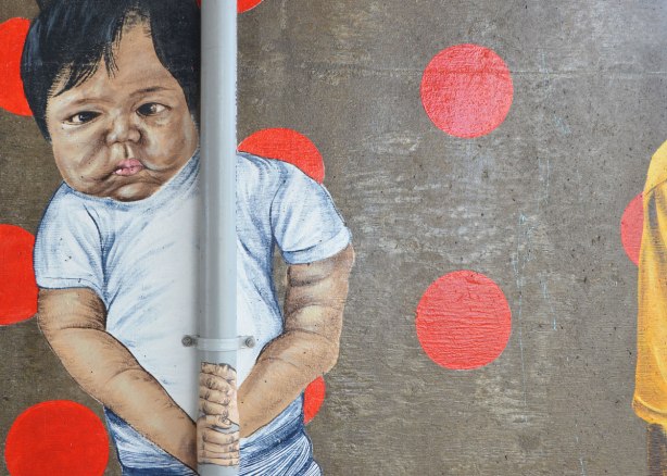 painting of a toddler on a concrete support, street art 