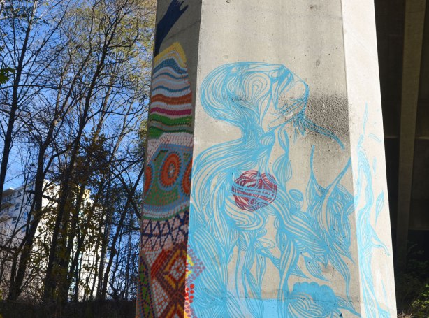 side of a concrete pillar with light blue line drawing of person looking upwards, abstracted. 