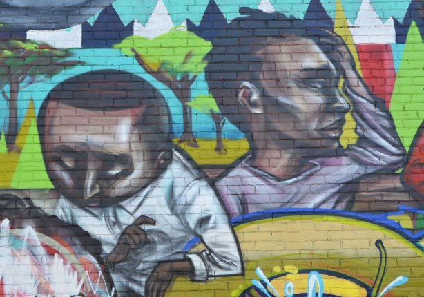 part of a larger mural, the face and heads of two young black men. 