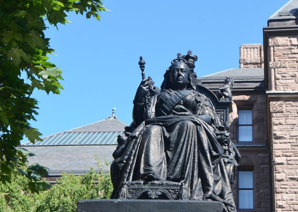statue of Queen Victoria in bronze. She's seated, wearing crown and holding mace/staff