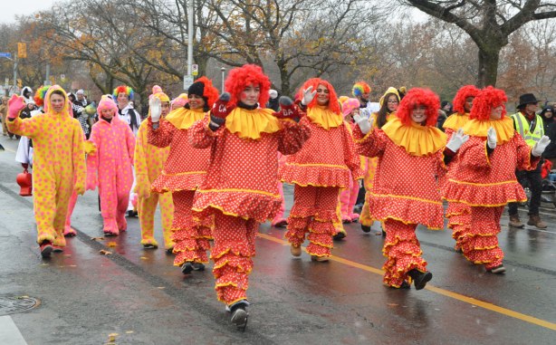Santa Claus parade - many people dressed like raggedy Ann dolls in pink, orange and yellow with bright red hair. 