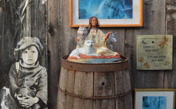 old black and white photo of a boy, a small statuette of a woman and three wolves, dragonflies on a picture frame with a photo of the word love