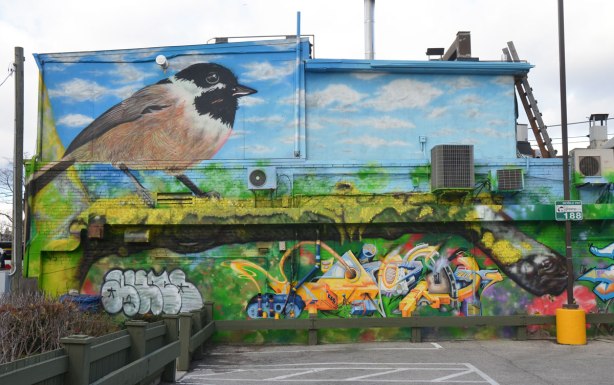 large mural of a chickadee, flowers, and butterflies 