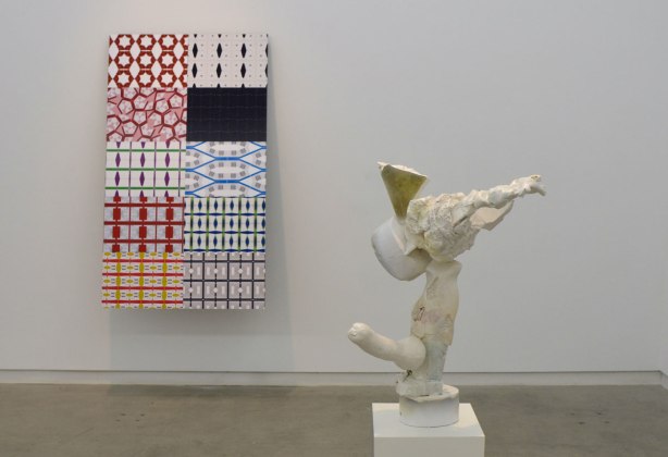 artwork by David Armstrong Six (sculpture) and Kristan Horton (prints on the wall) at the Clint Roenisch gallery - one sculpture on the floor and one panel on the wall. The panel is a 10 sections, each section is a different pattern made of labels from packaging. 