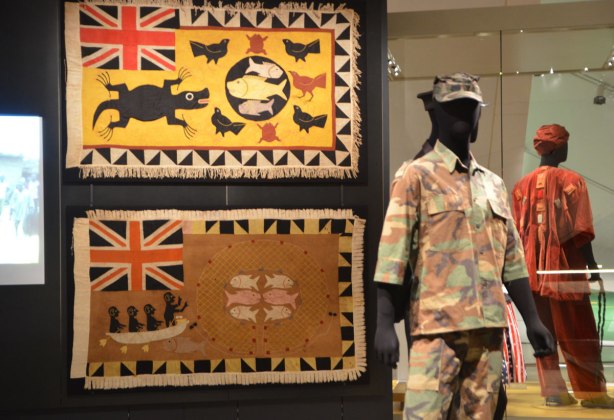 two flags displayed on a black background, with two male mannequins dressed in military Ghanese costume. 