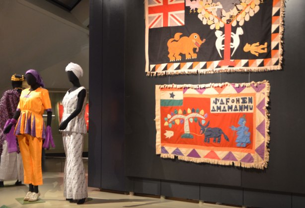 two flags displayed on a black background, with three femail mannequins dressed in traditional Ghanese costume. 