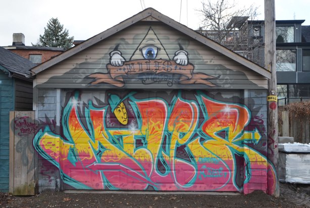 street artist miles tag and colourful street art on a garage door 