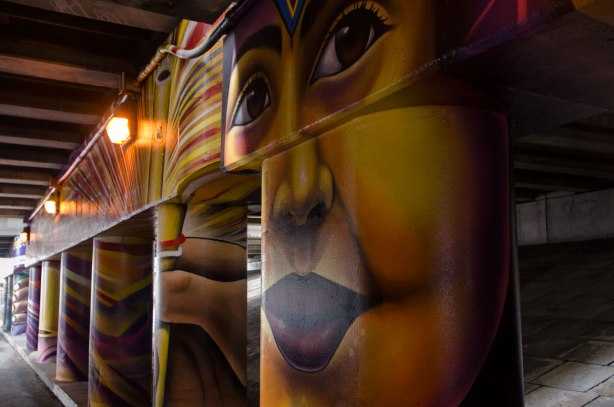 pillars and supports under an overpass that have been painted in bright colours by smoky and shalak 