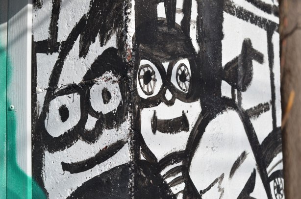 part of a larger mural, black line drawings on white of two smiling faces