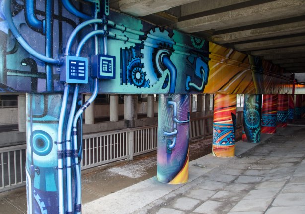pillars and supports under an overpass that have been painted in bright colours by smoky and shalak 