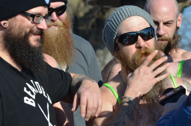 people participating in the 12th annual polar bear dip at Sunnyside Park in Toronto, in the icy cold water of Lake Ontario - members of bearded villains team