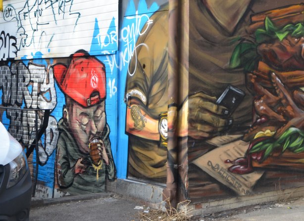 a man in a red baseball cap on backwards is drinking, 