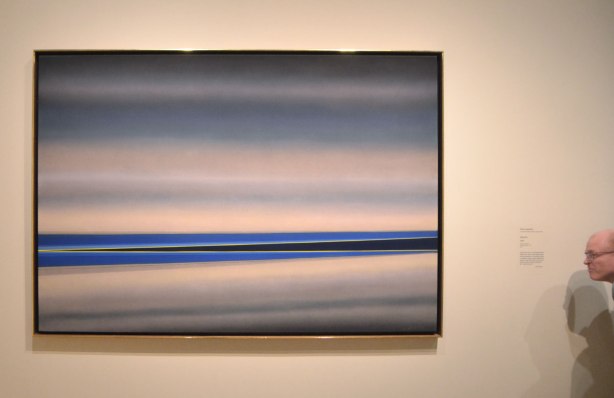 horizontal lines, some parallel and some at slight angles, in blues and greys, painting on a gallery wall called Aforim by Rita Letendre