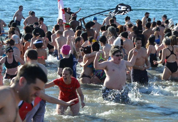 people participating in the 12th annual polar bear dip at Sunnyside Park in Toronto, in the icy cold water of Lake Ontario