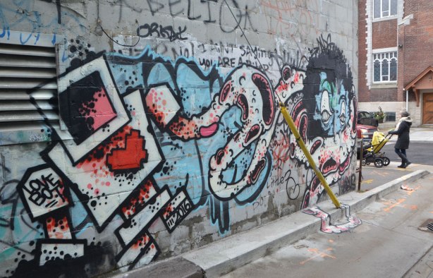 a lovebot mural in an alley, he looks to be fighting a grominator monster